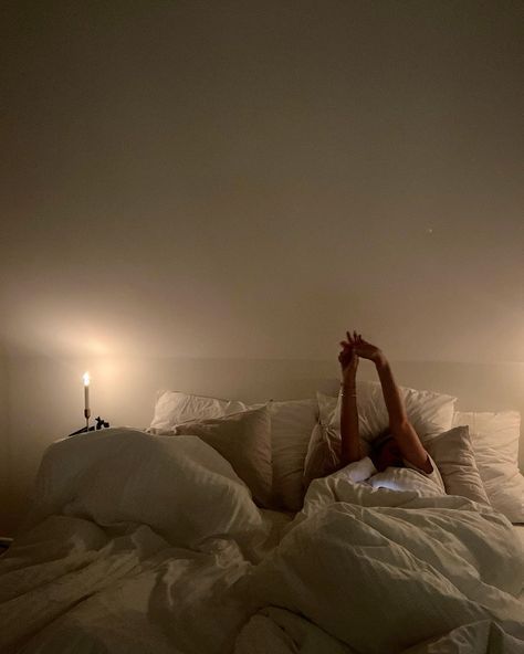 A quiet evening — stretching in bed by candlelight